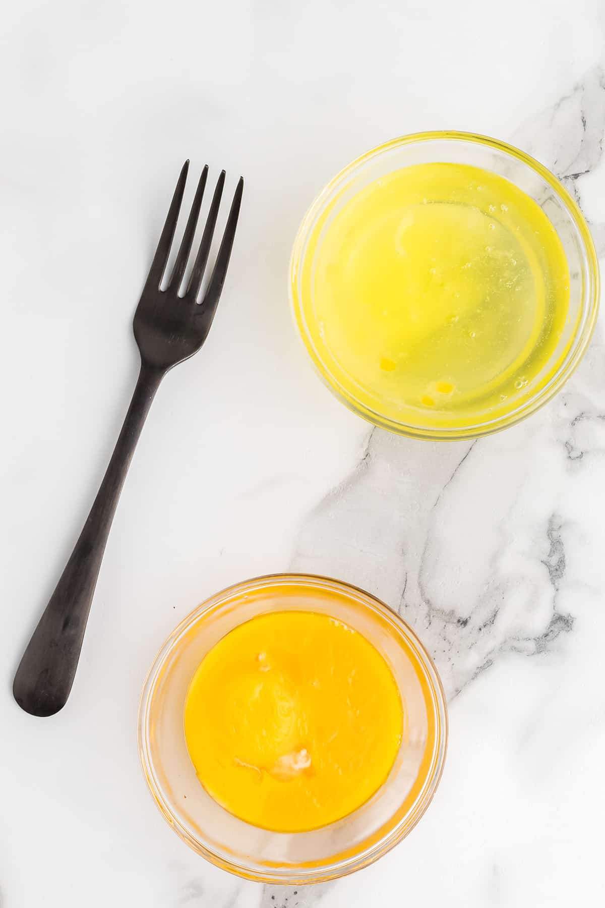 Egg white and yolks in two small bowls.