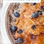 A plate of oatmeal blueberry pancakes topped with fresh blueberries and syrup.