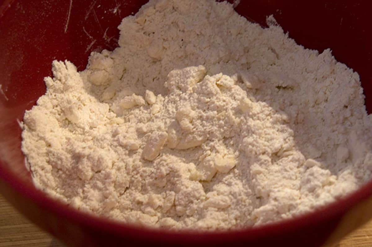 Butter worked into dry ingredients in a mixing bowl.