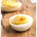 A close-up of a deviled egg topped with paprika on a wooden board, with text about southern-style recipes.