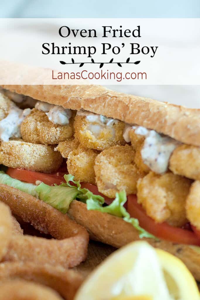 Shrimp po' boy sandwich with onion rings and lemon wedges.