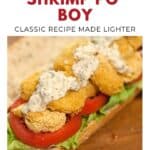 Oven-fried shrimp po boy sandwich with lettuce, tomato, and sauce on a hoagie roll.