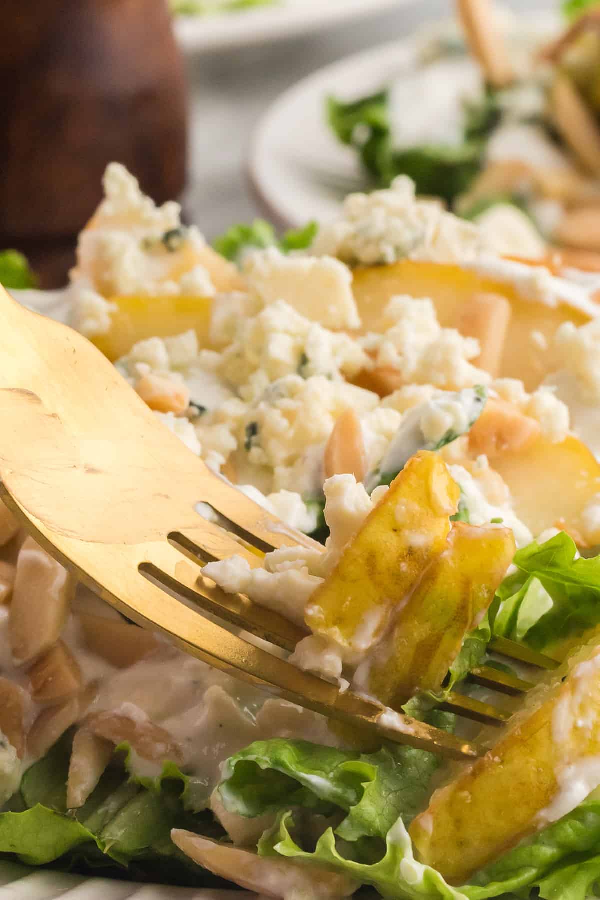 Pear and blue cheese salad with a gold tone fork.