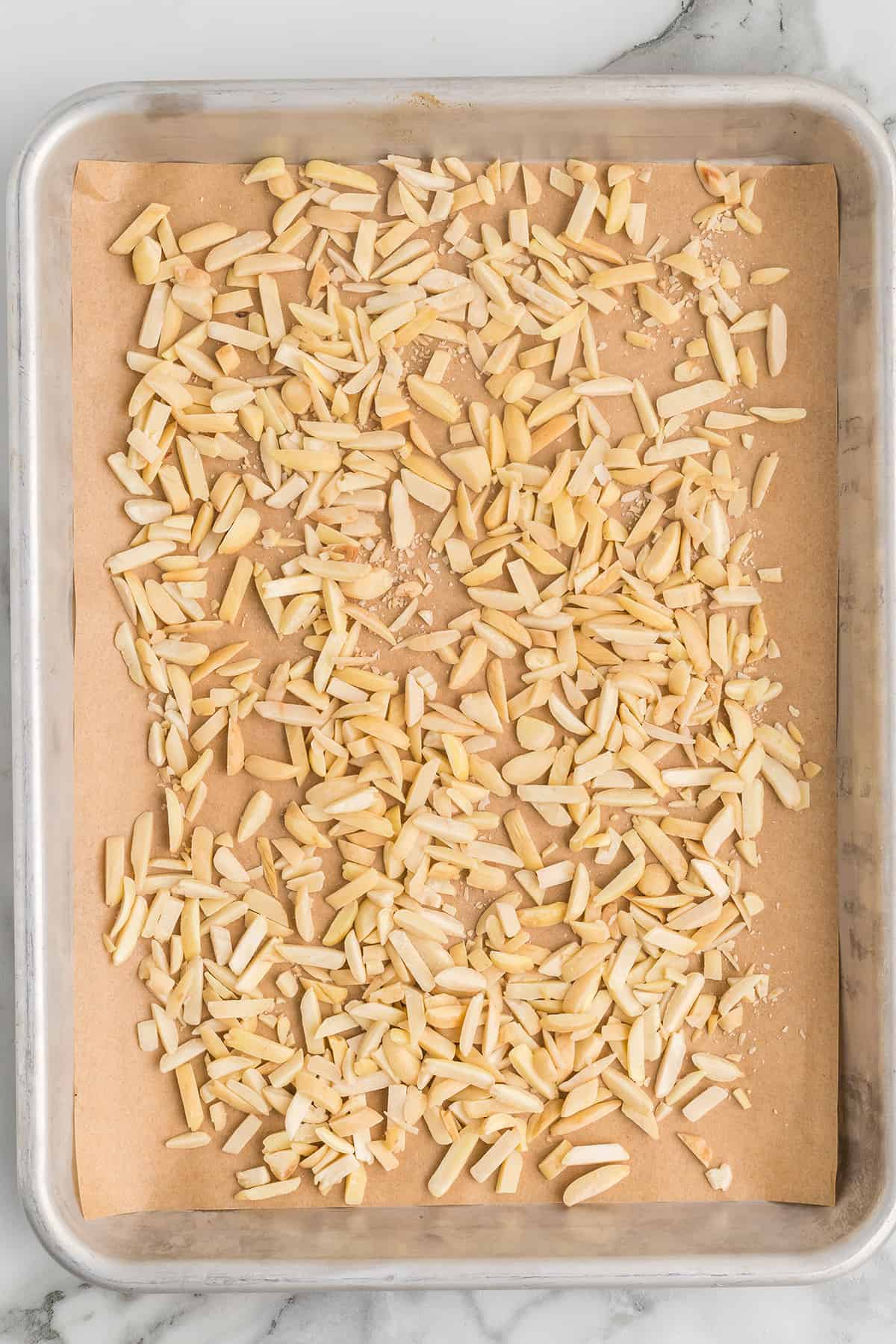 Slivered almonds on a baking sheet.