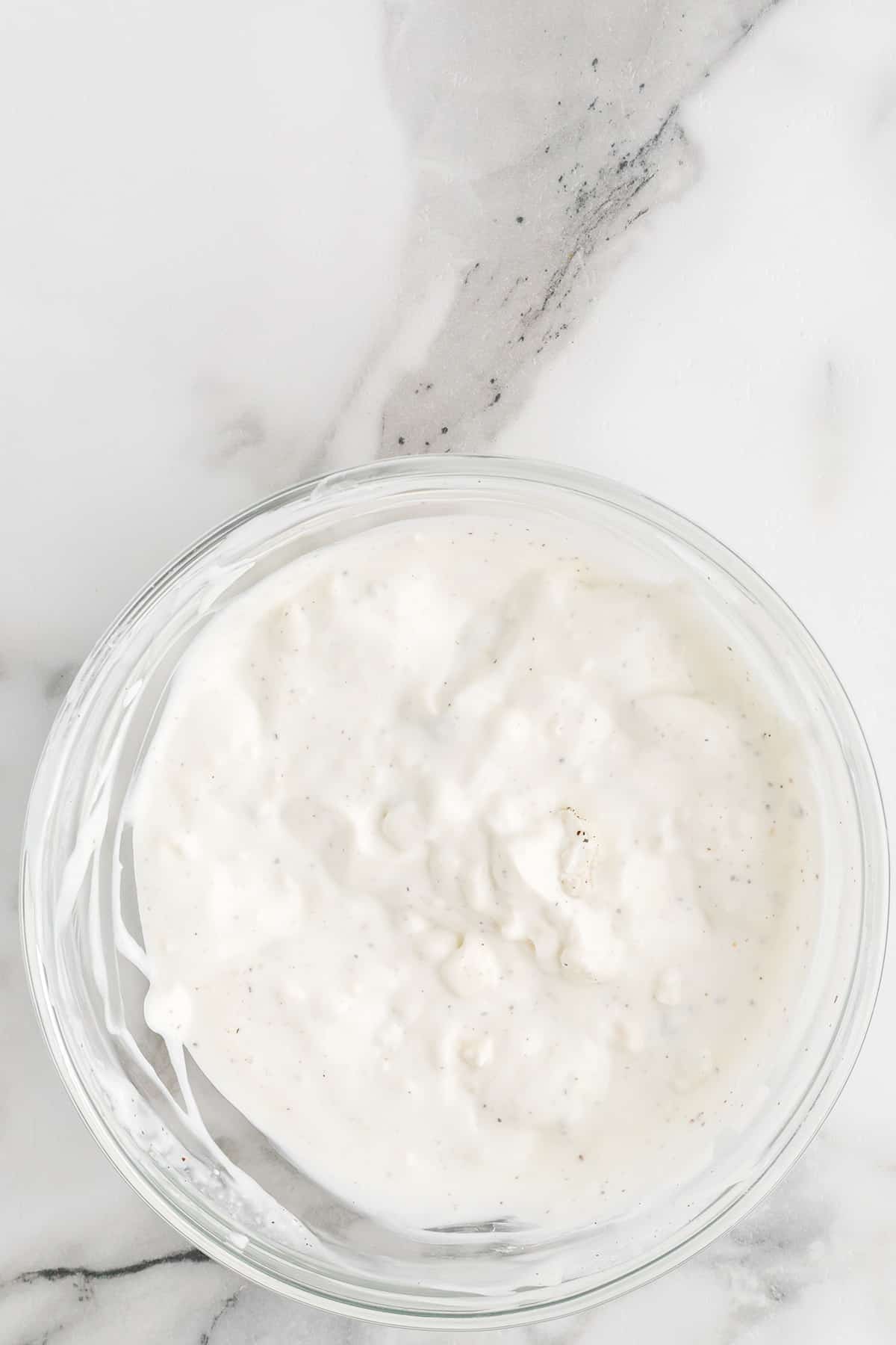 Dressing ingredients in a glass mixing bowl.