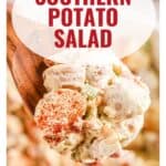 A wooden spoon holds creamy southern potato salad topped with paprika. Text: Southern Potato Salad.