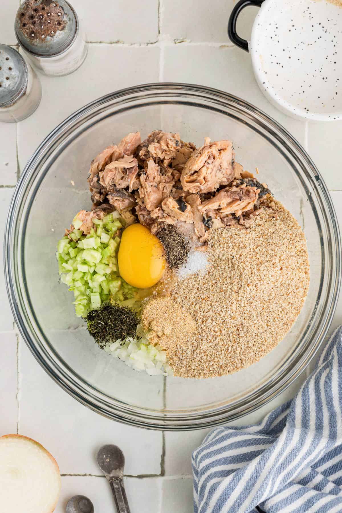 Ingredients for salmon croquettes in a large glass bowl before being mixed.