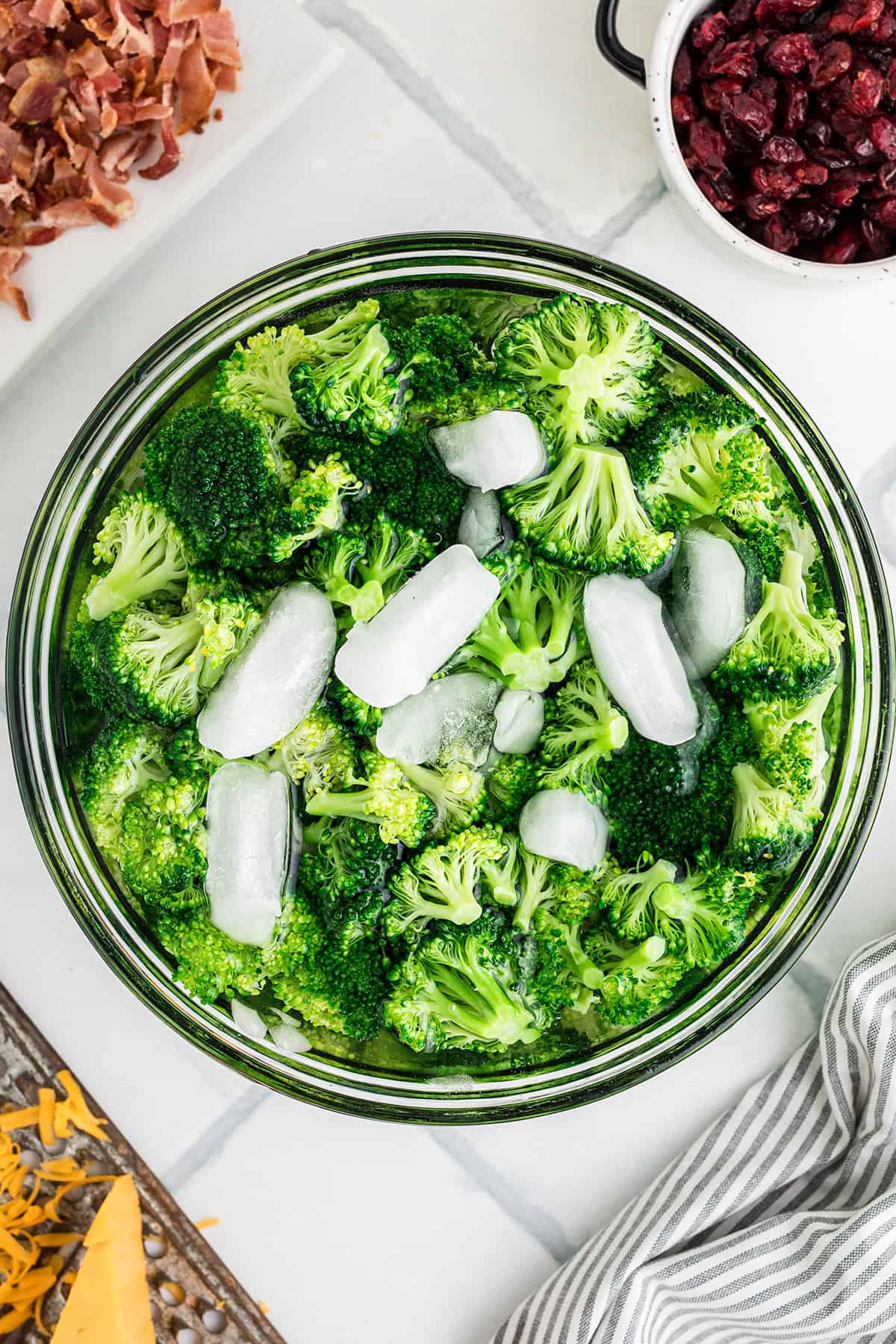 Blanched broccoli being cooled with ice.