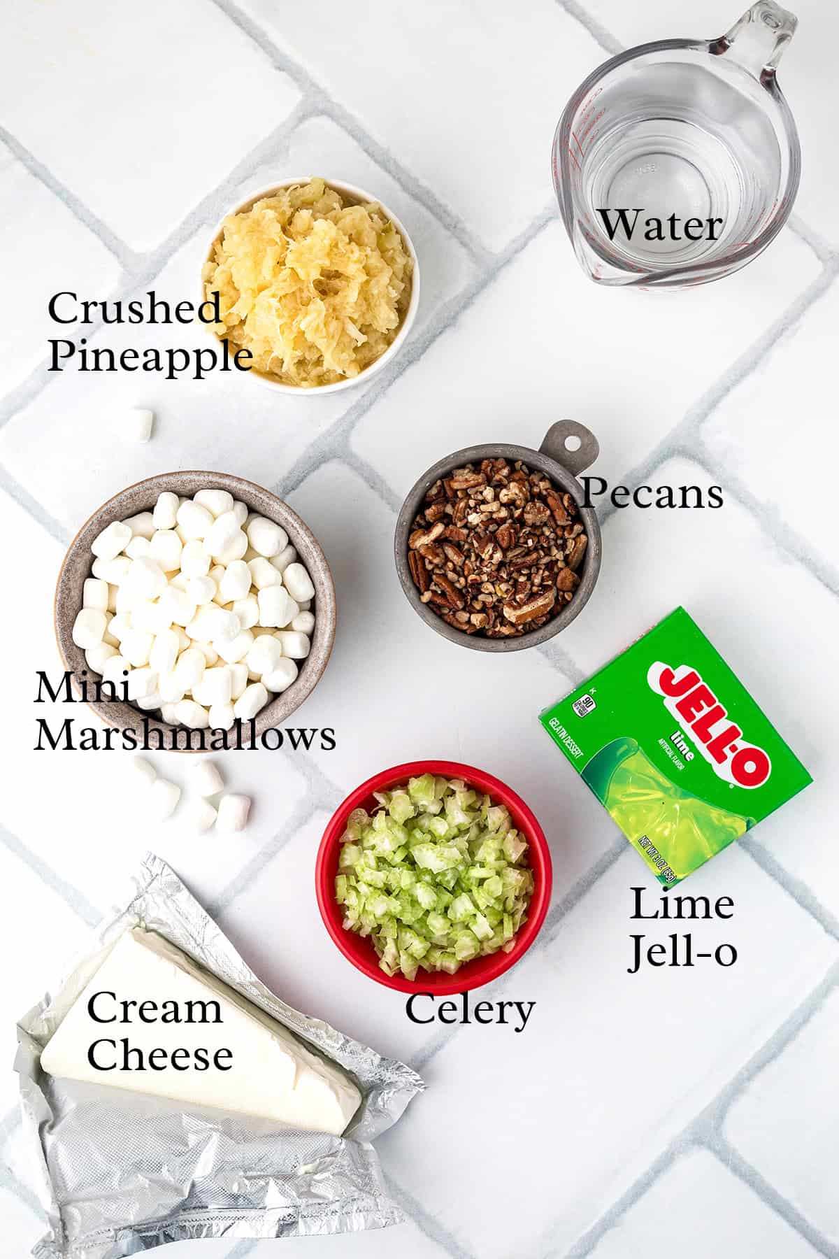 Ingredients for a lime Jell-O salad displayed on a white tile background, labeled with text.