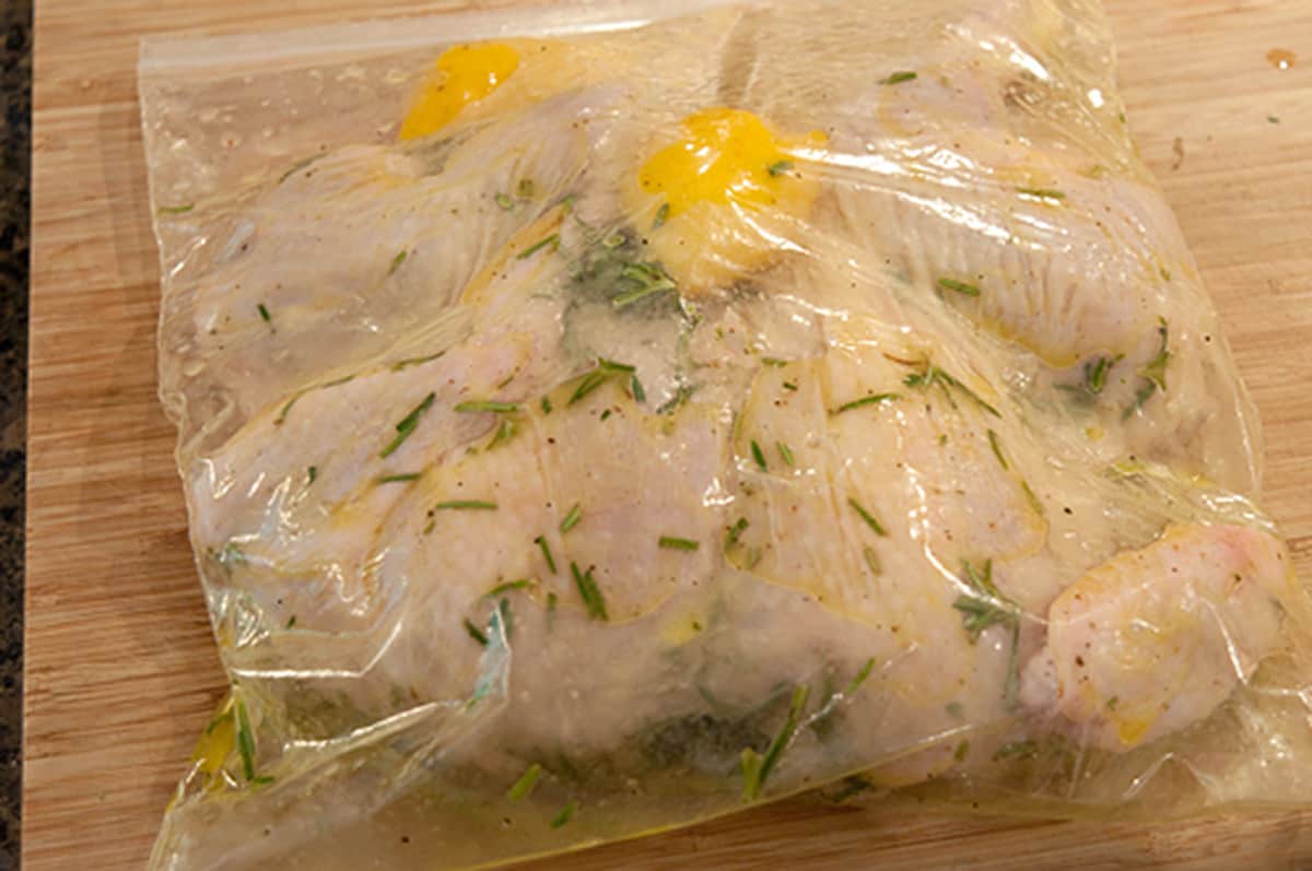 Chicken added to the marinade in a resealable plastic bag.
