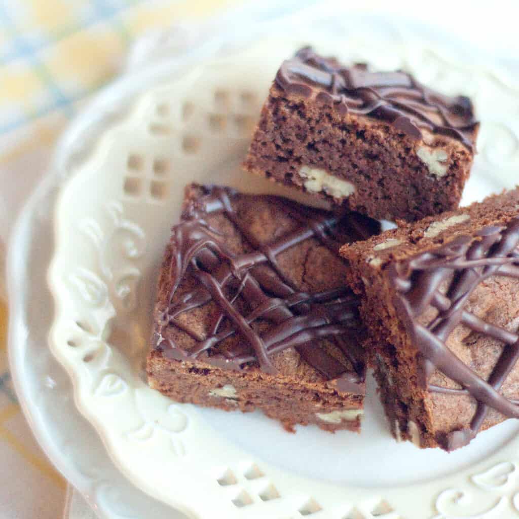 Finished brownies on a white serving plate.