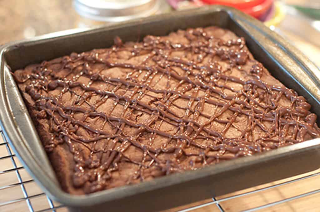 Chocolate drizzle added to the top of cool brownies.