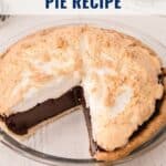 A chocolate meringue pie with a slice missing, topped with golden meringue in a glass pie dish.