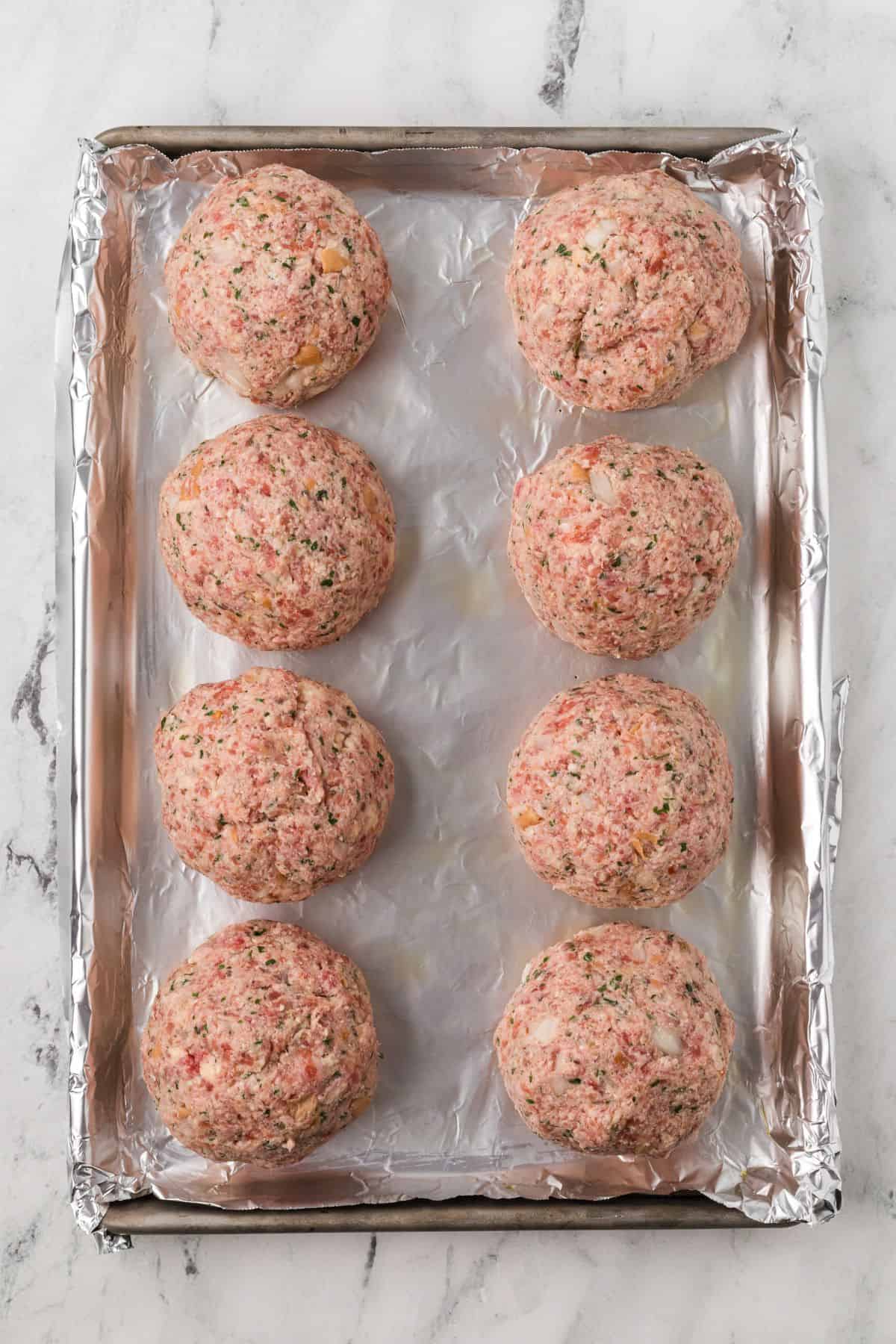Meatballs placed on a baking sheet.