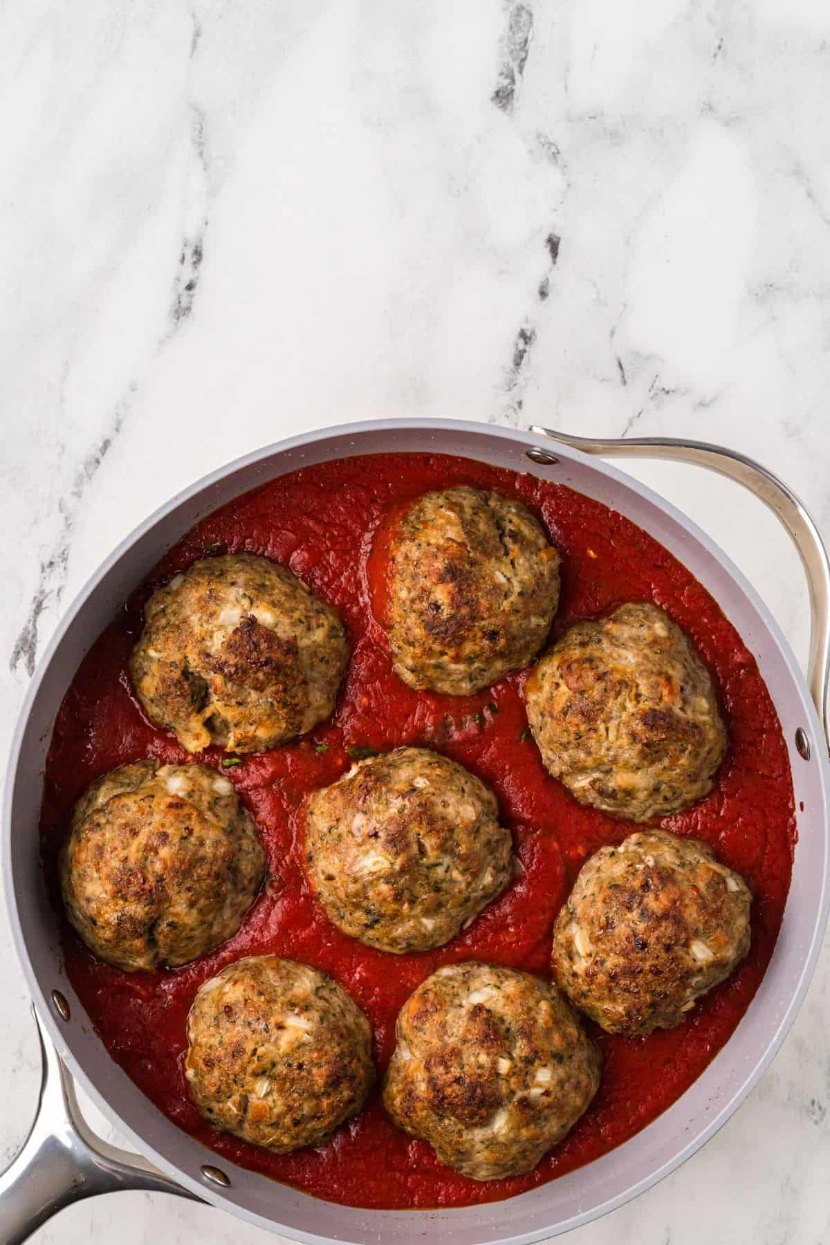 Browned meatballs added to tomato sauce.