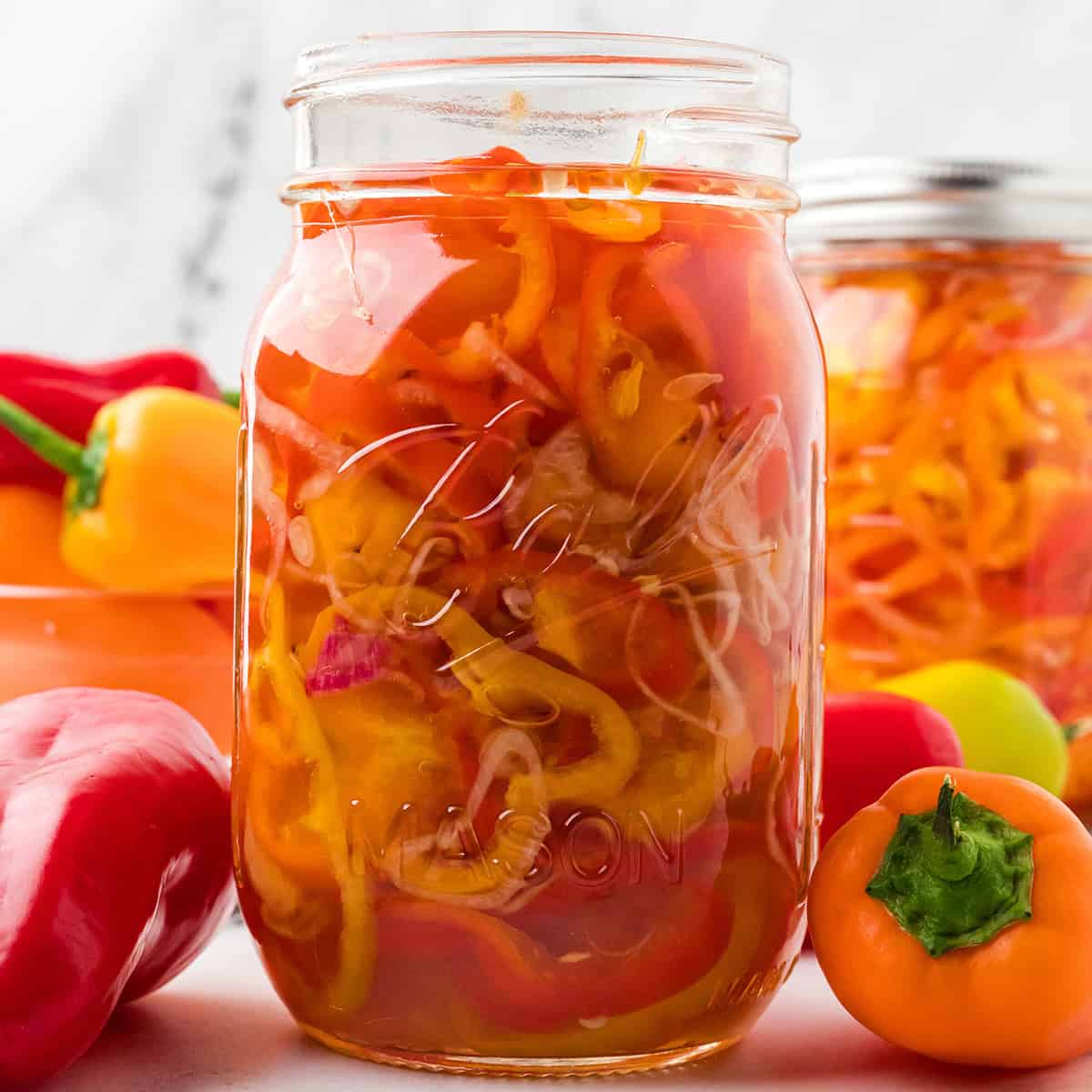 A canning jar filled with pickled peppers and shallots.