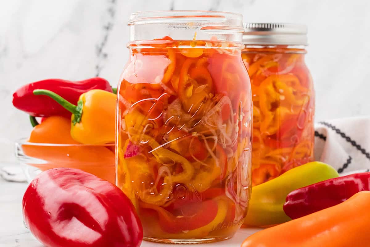A canning jar filled with pickled peppers and shallots.