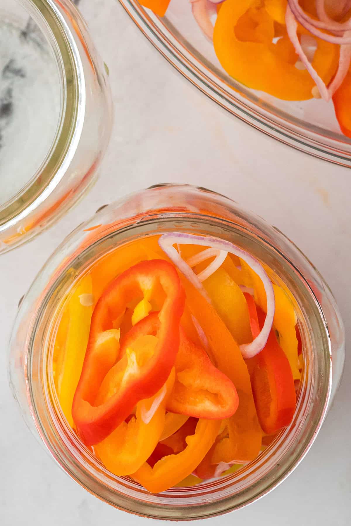 Peppers and shallots packed in a jar.