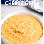 A white bowl of creamy Southern cheese grits sprinkled with pepper, with a blue-striped towel beside it.