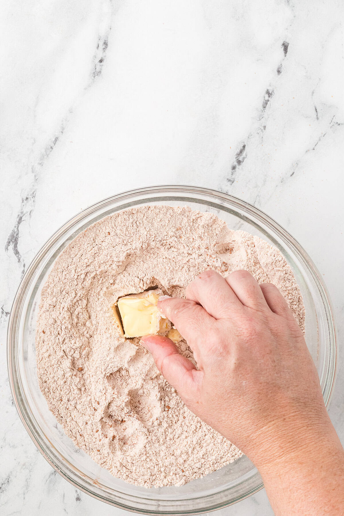 Mixing softened butter into the flour mixture.