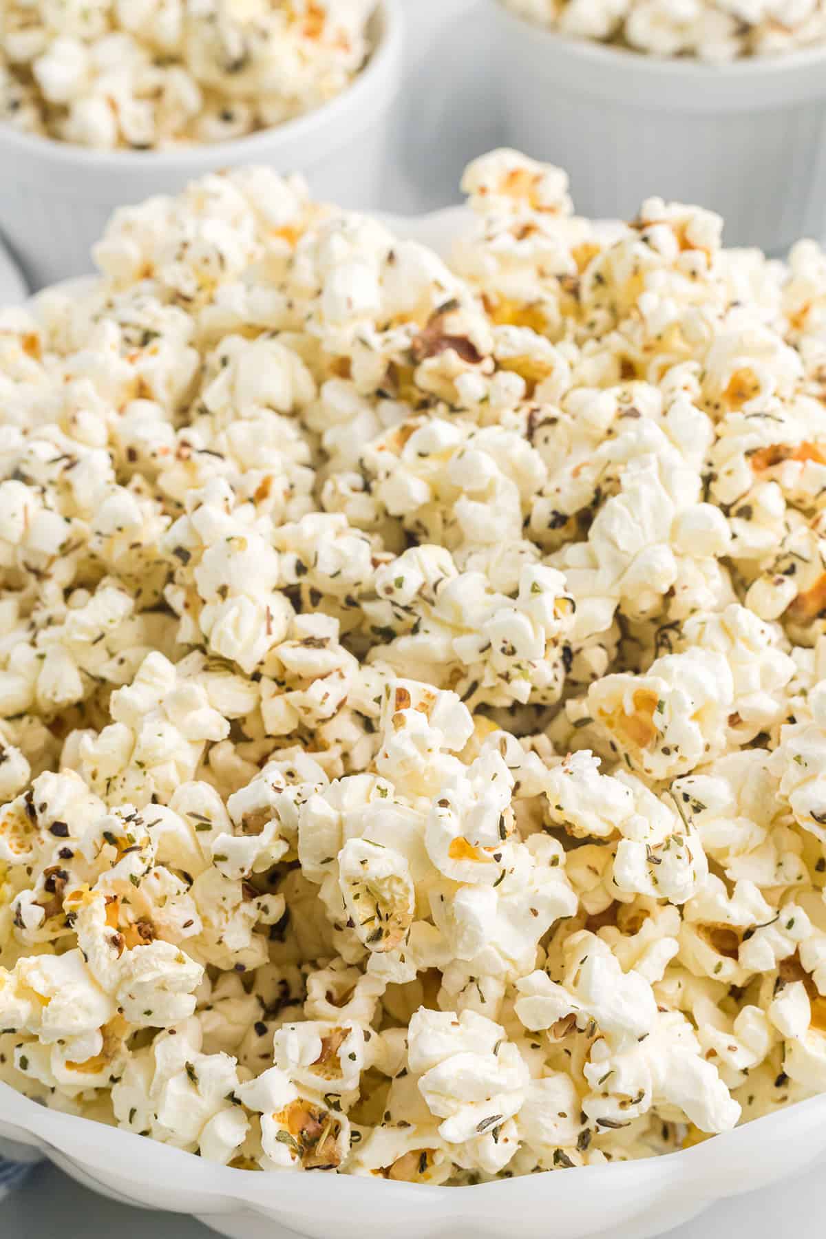 A white serving bowl filled with popped corn.