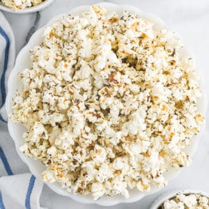 A white serving bowl filled with popcorn.