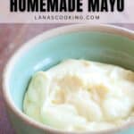 A bowl of homemade mayonnaise sits in a green ceramic dish on a wooden surface. Text above reads, Make Your Own Homemade Mayo lanascooking.com.