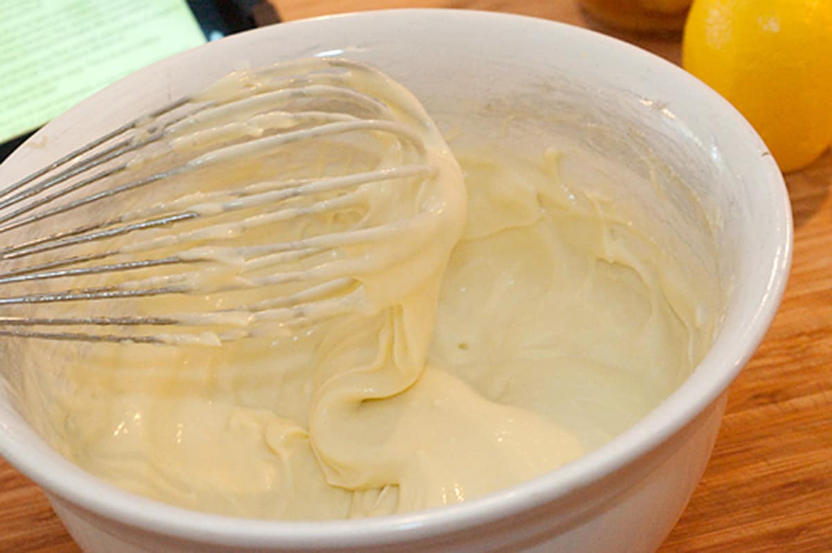 Finished homemade mayonnaise in a white mixing bowl.
