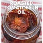 A jar of oven roasted tomatoes in oil sits on a red and white striped towel.