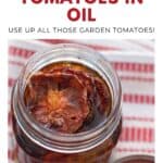 A jar of oven-roasted tomatoes in oil sits on a striped towel, photographed from above.