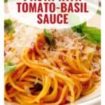 Delicious pasta with fresh tomato-basil sauce, topped with grated cheese and herbs.
