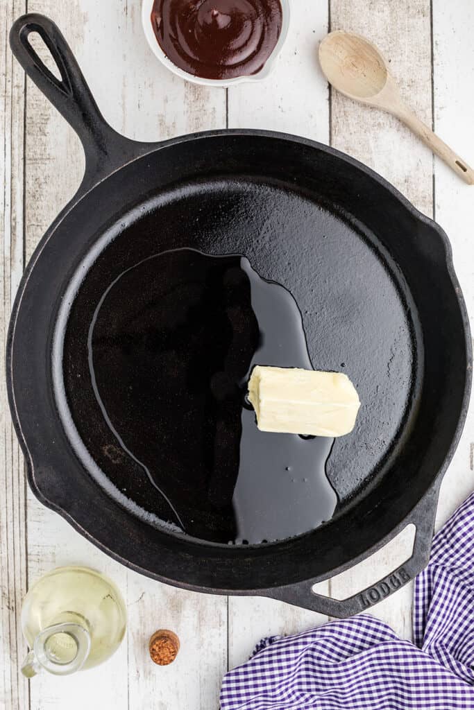 Canola oil and butter in a black iron skillet.