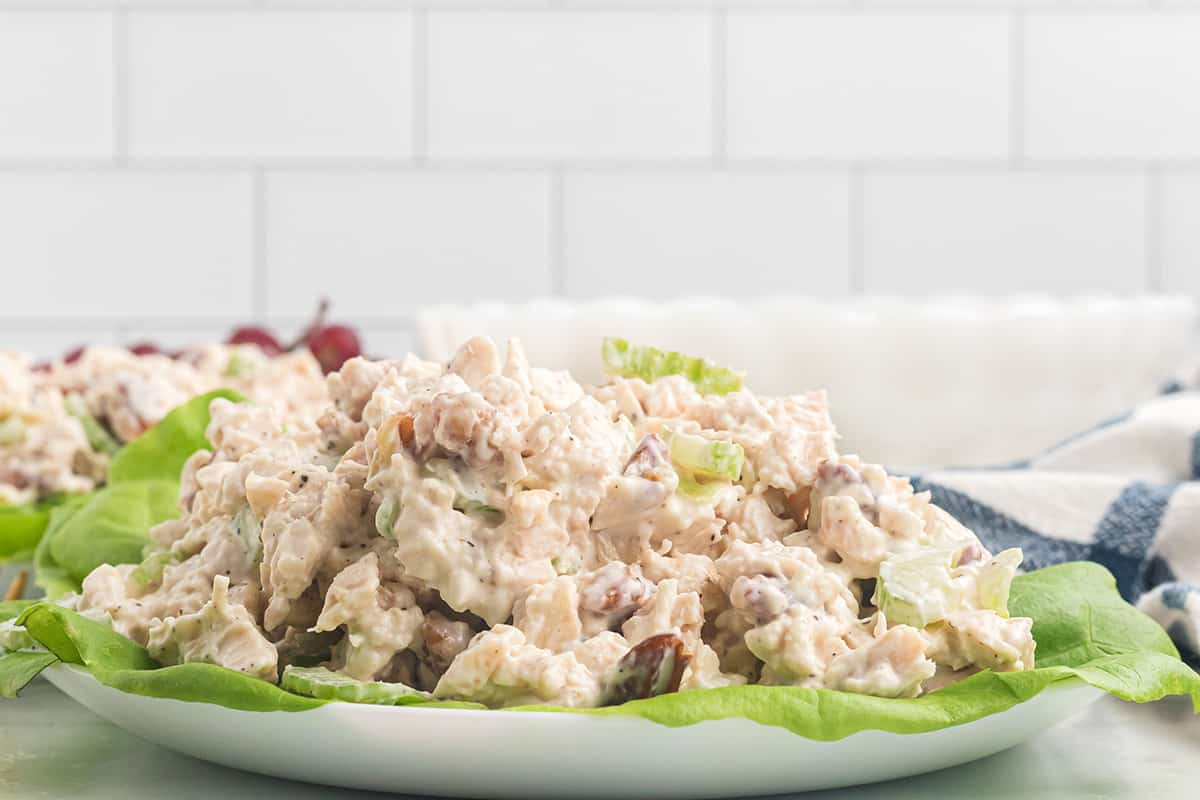 A mound of chicken salad on a lettuce lined plate.