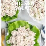 Chicken salad with celery and pecans served on lettuce leaves, with a fork and cloth napkin beside the plates.