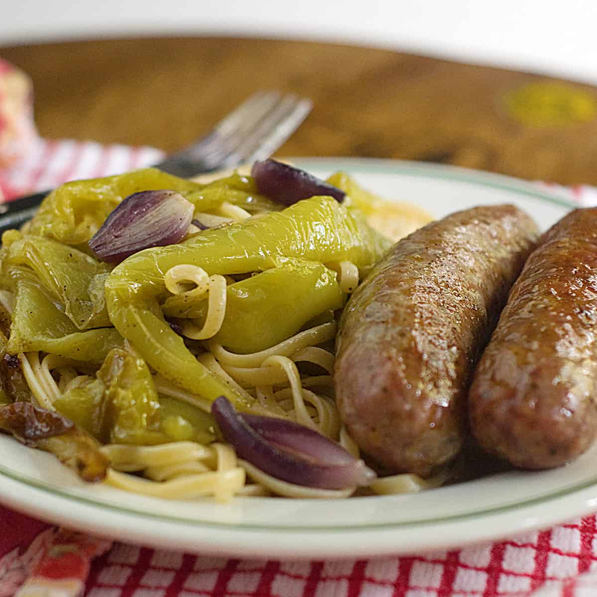 A serving of Italian Sausage with Roasted Peppers on a white plate.