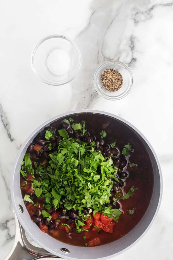 Tomatoes and other ingredients added to the saucepan.