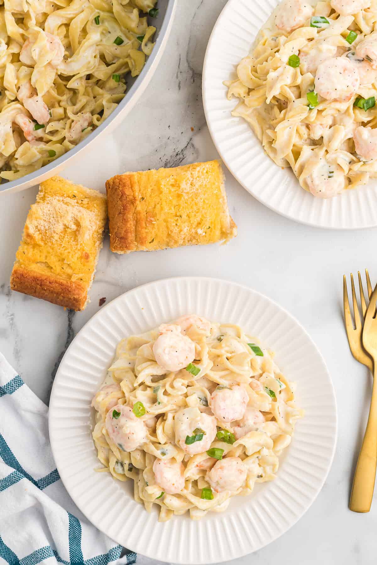 A serving of creamy shrimp pasta on a white plate.