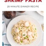 Plate of creamy shrimp pasta garnished with herbs on a white table, next to salt and pepper shakers.