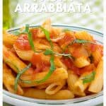 Plate of penne pasta with tomato sauce, bacon, and fresh basil, labeled Pasta Arrabbiata.