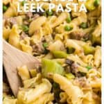 Close-up of sausage and leek pasta with peas, noodles, and a wooden spoon, captioned as a family favorite dinner.