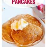 Two pancakes topped with butter and syrup on a white plate, with Spiced Pear Pancakes text above.