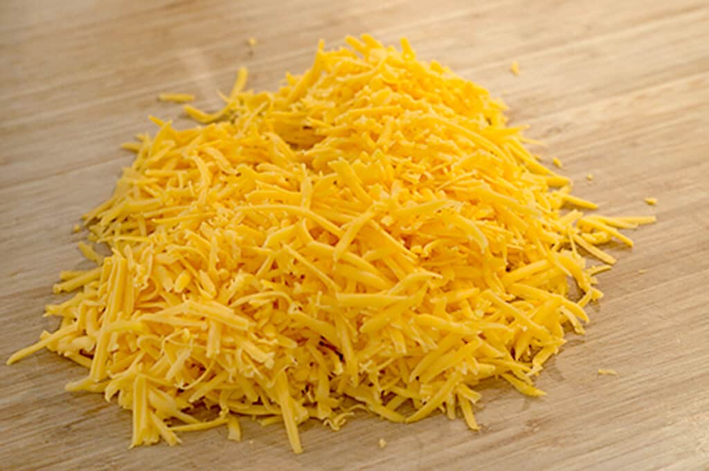 A mound of grated cheddar cheese.
