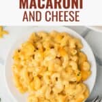 A dish of classic macaroni and cheese with a spoon inside taking a scoop out.
