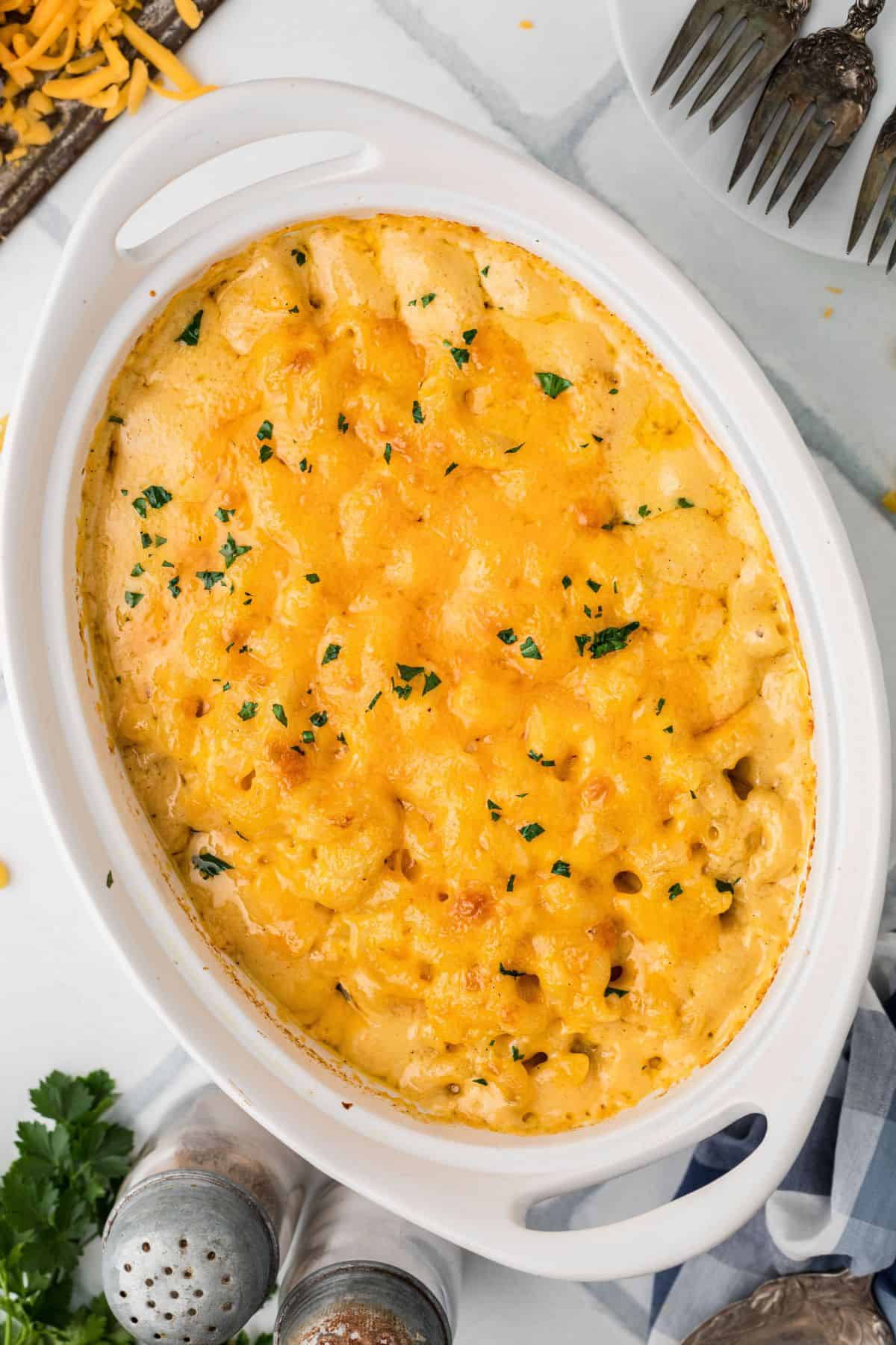 Baked macaroni and cheese with melted cheese on top and parsley for garnish.