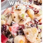 Close-up of cranberry Waldorf salad with apples, cranberries, celery, and walnuts in a creamy dressing.