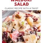Close-up of cranberry Waldorf salad with apples, celery, pecans, and cranberries in a creamy dressing.