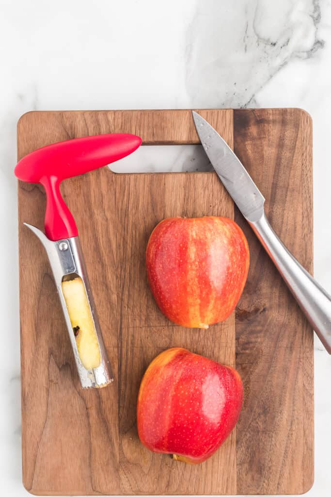 Coring and chopping apples on a wooden board.