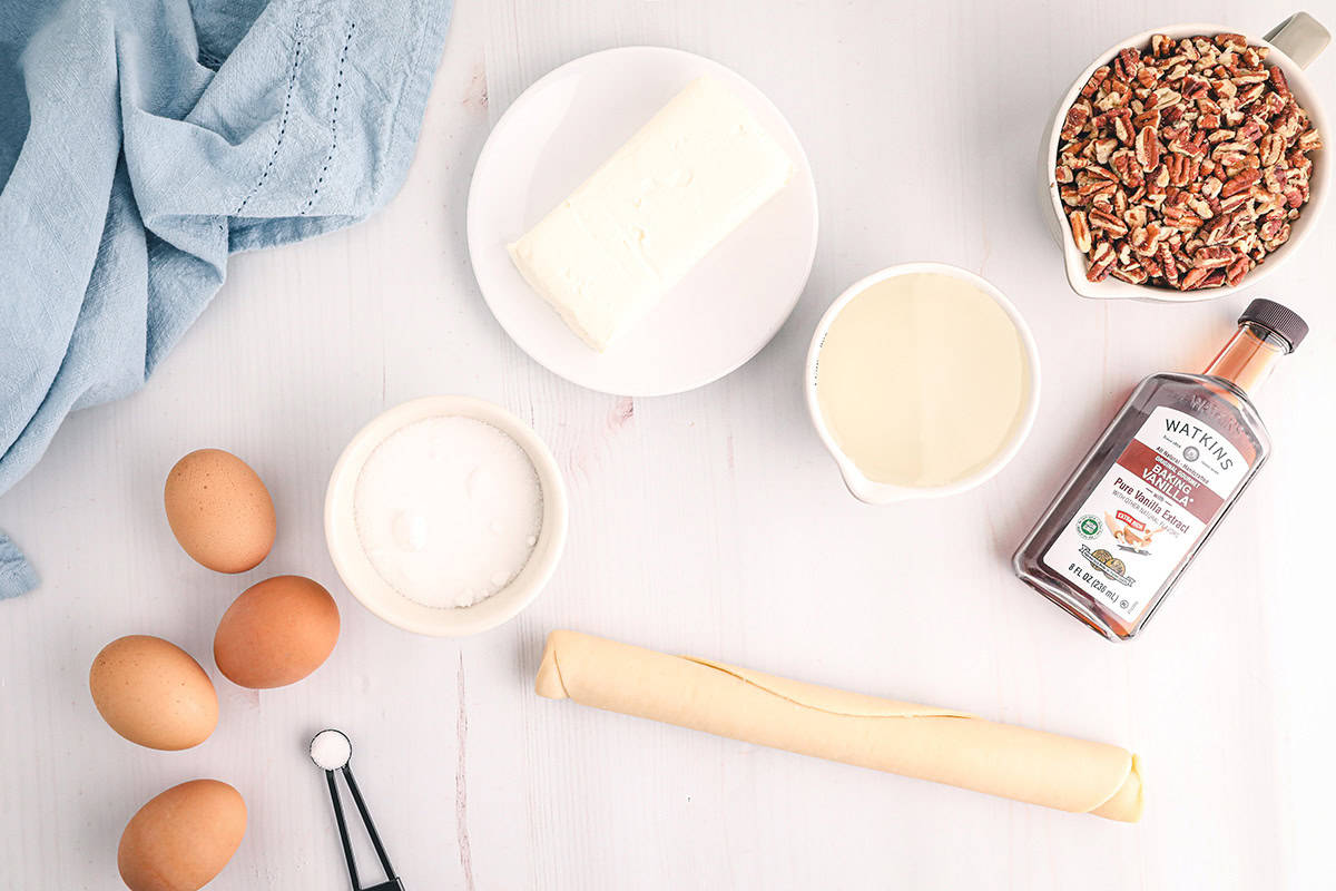 All the ingredients required to make a pecan cheesecake pie.