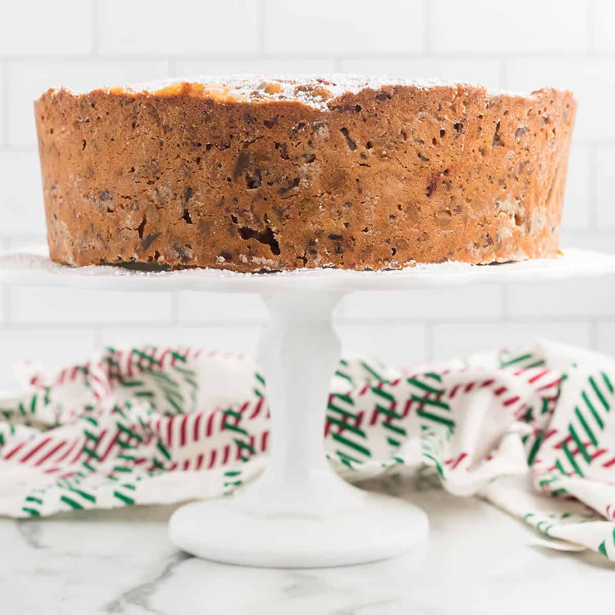 Finished fruitcake on a cake pedestal.