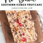 No bake Southern icebox fruitcake with nuts and cherries on a wooden board.